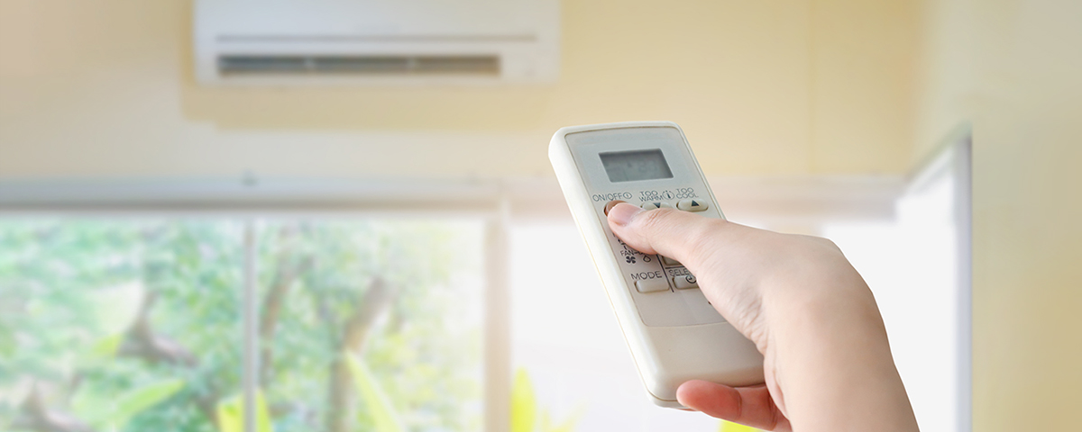 person using remote for HVAC wall unit